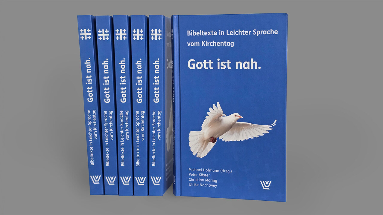 Das Buch "Gott ist nah", mehrere Exemplare stehen neben einander; das Cover zeigt eine fliegende, weiße Taube auf blauem Grund